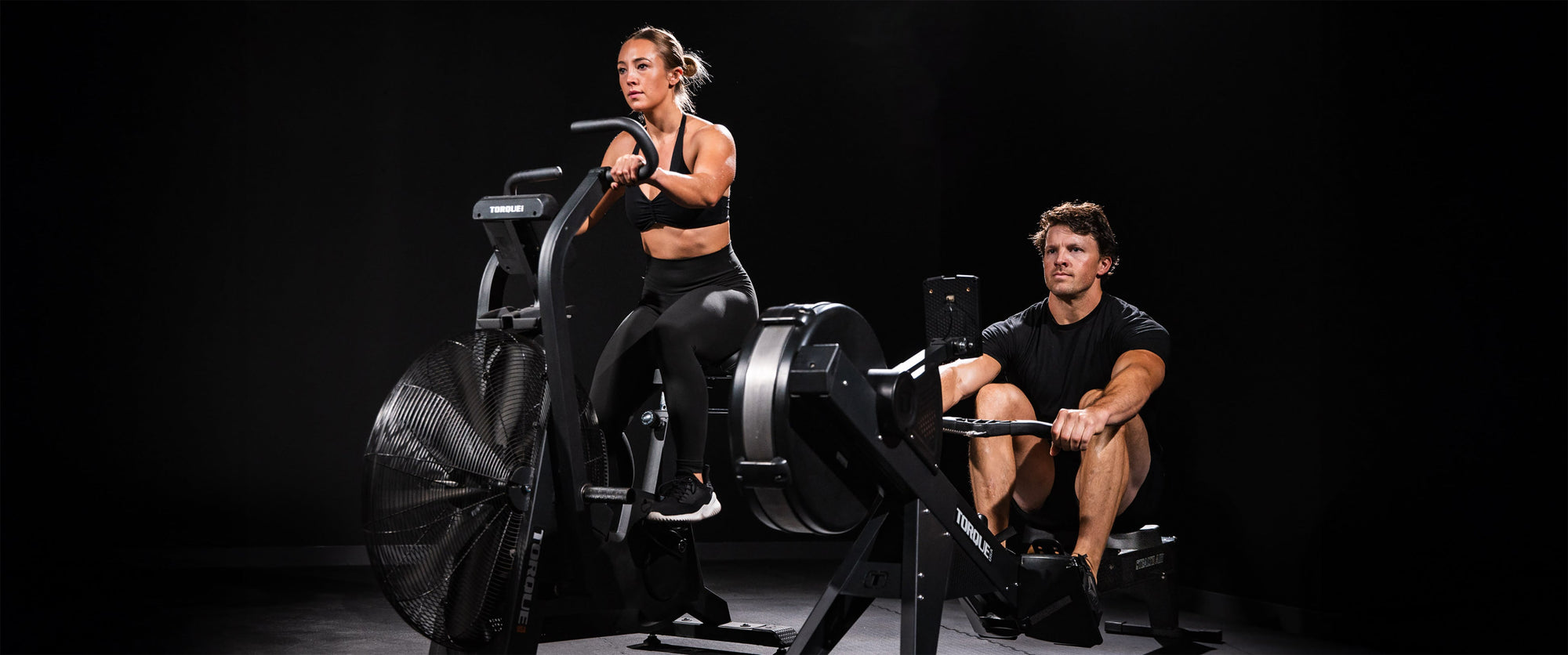 Woman Training With AssaultBike Air Bike In Garage Home Gym