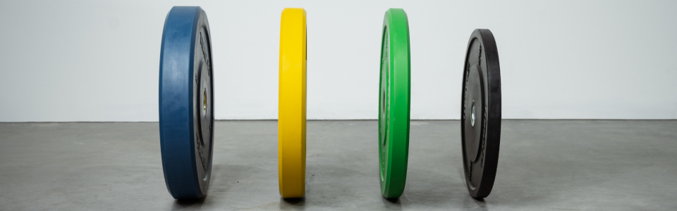 Colored and Black Bumper Plates In A Line of Different Weight Varieties