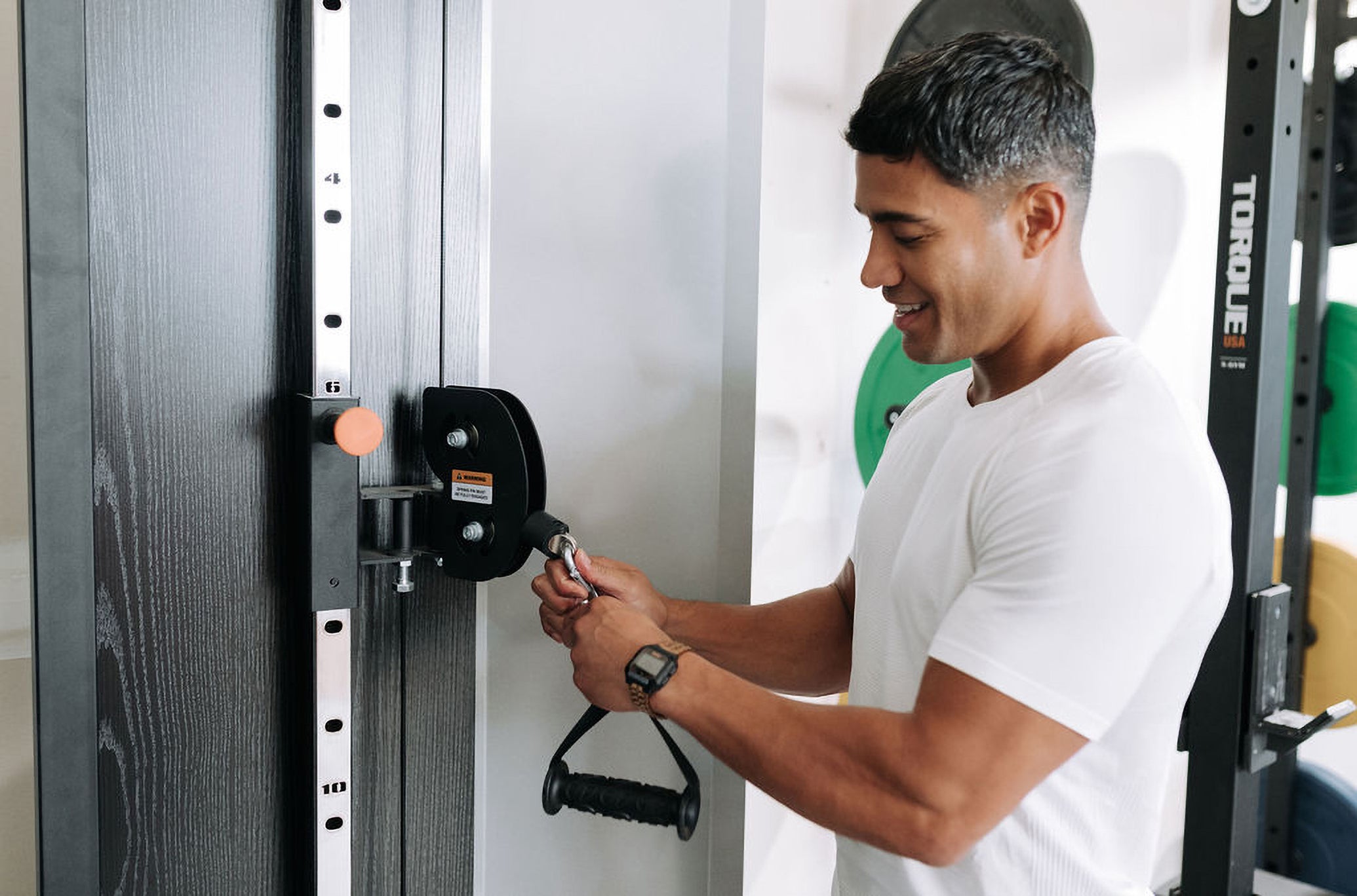 Man Adjusting F9 Functional Trainer Accessory