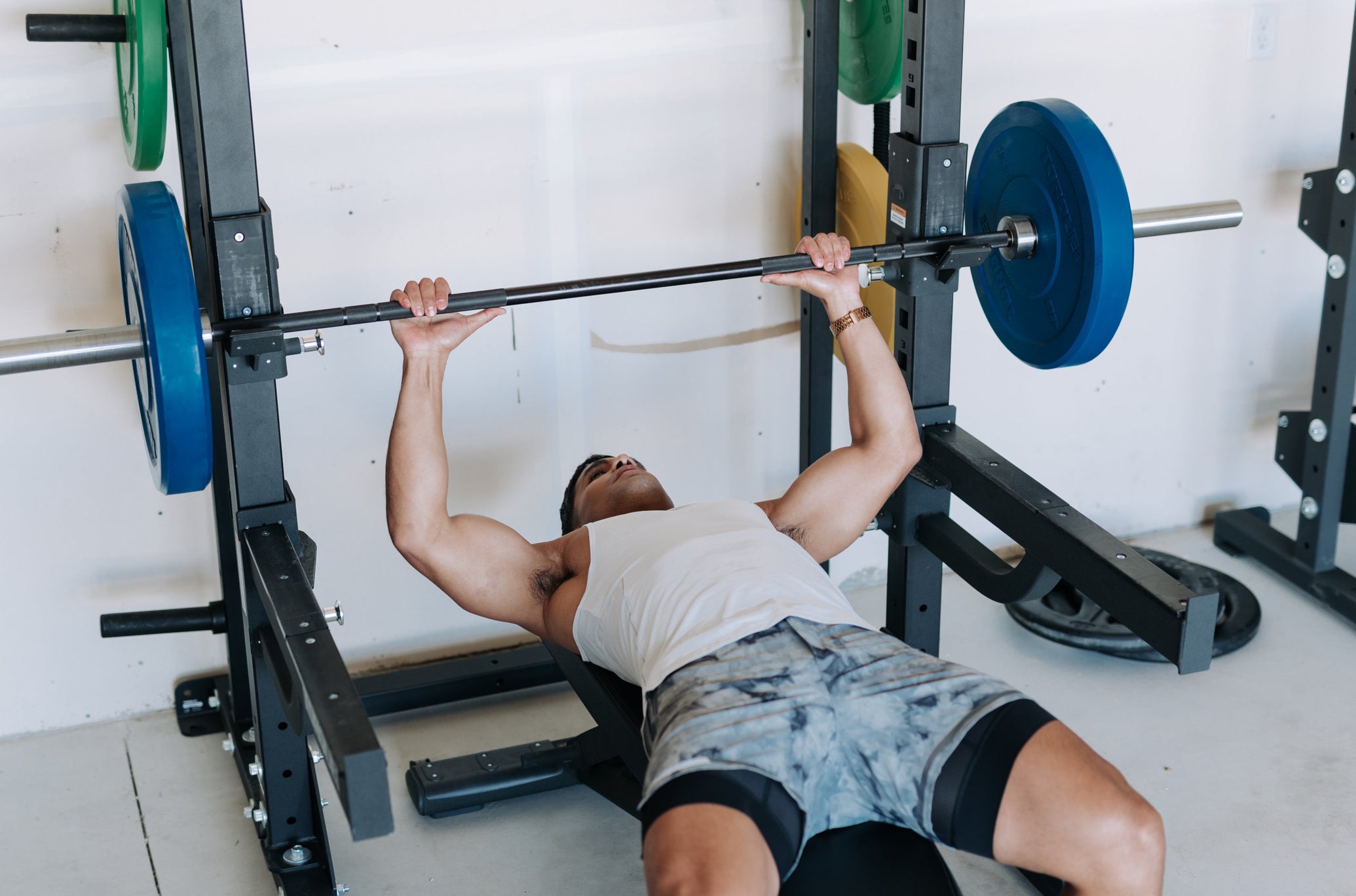 Man Lifting With Torque Rack and Colored Bumper Plates